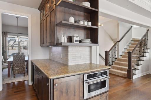 Butler pantry with convection microwave and wine fridge. Display shelves.