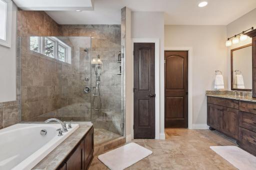 Primary bath with walk-in shower, soaking tub, in floor heat, dual vanity, and large walk-in closet.