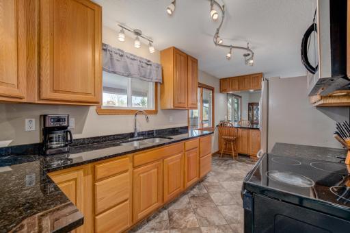 remodeled kitchen with tile floors, granite counters and stainless steel appliances