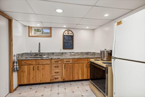 There is an adjacent brand-new kitchenette with hickory cabinets and granite countertops, a farmhouse stainless sink and waterfall plumbing fixture, electric “old school” oven and refrigerator.