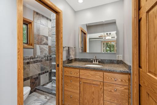 Owner's suite boasts an updated 3/4 bath with slate/ceramic tile, glass block, granite countertops, and a lovely walk-in closet.
