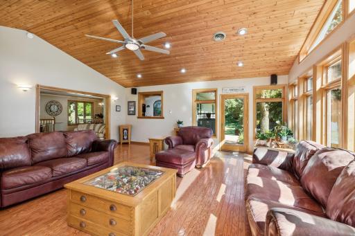 The great room boasts heated floors underneath the oak floors, has white cedar ceilings with recessed lights and a cathedral vault.