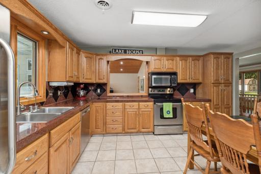 The kitchen on the main level is dressed in oak cabinetry, stainless steel appliances, granite countertops and backsplash, and has a see-through window to the great room.