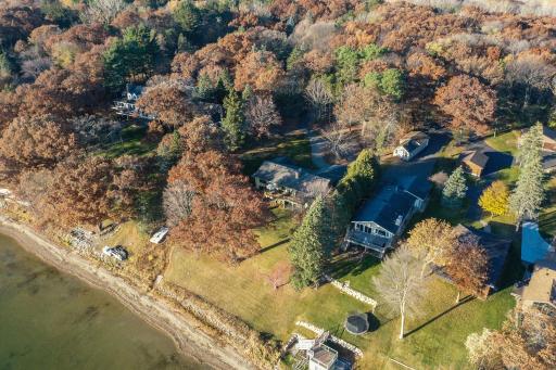Aerial View with expansive lakeside yard and view of wooded acreage.