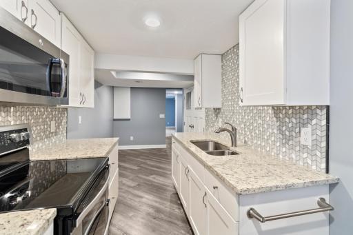 Second Kitchen with granite countertops and tiled backsplash - basement