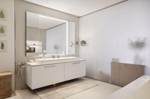 An etched glass wall allows natural light to filter into the owner's bath.
