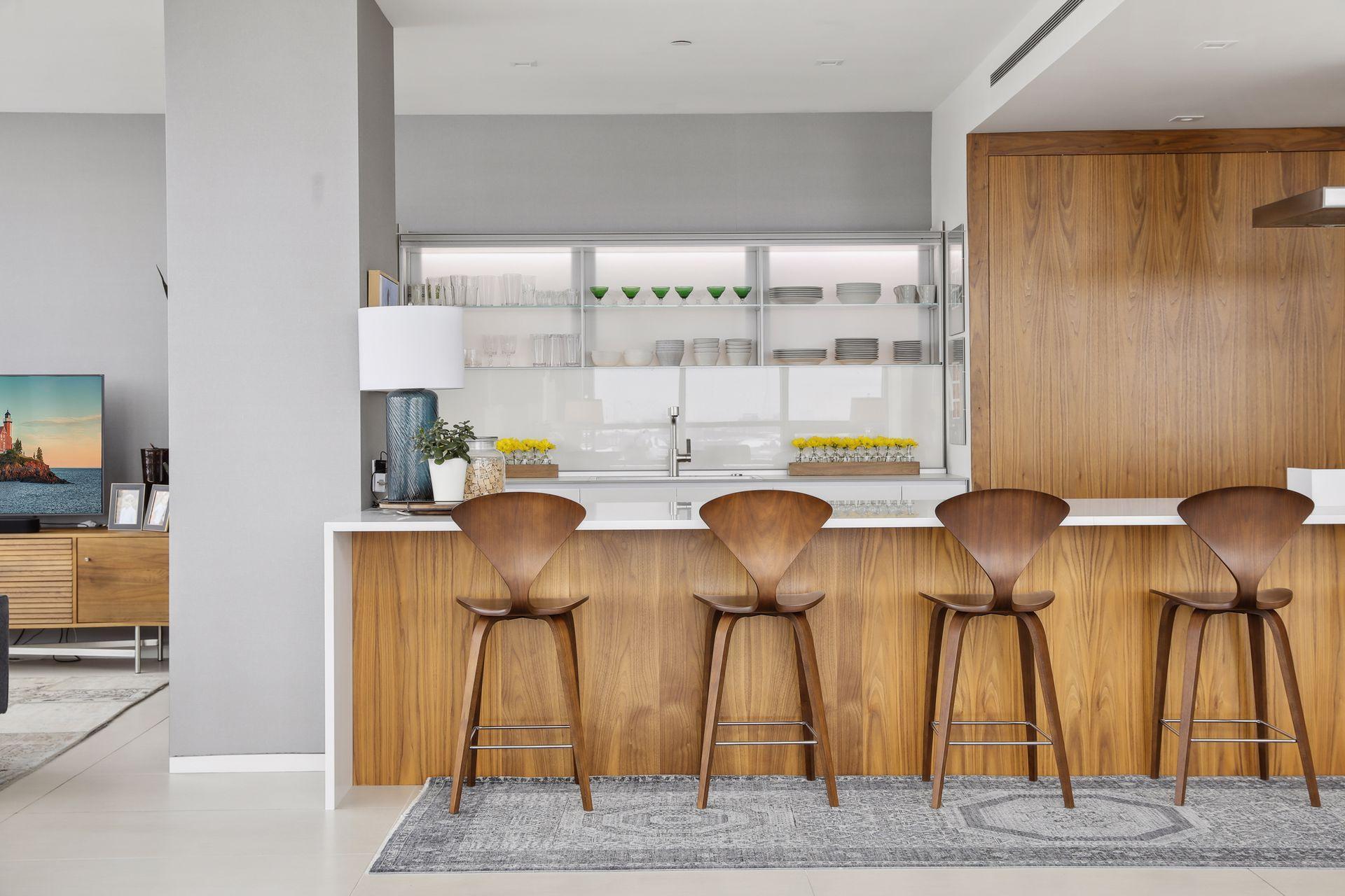 A sleek and modern designer kitchen features white italian glass cabinetry by Valcucine and the warmth of solid walnut accents. All stored items are concealed when cabinetry is closed. All appliances are integrated.