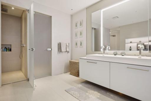 The luxurious spa-like owner's suite bath includes tile floors, a double vanity, a separate soaking tub with art display shelving above, a large walk in shower with built-in bench and etched glass door, and a water closet with an etched glass door.