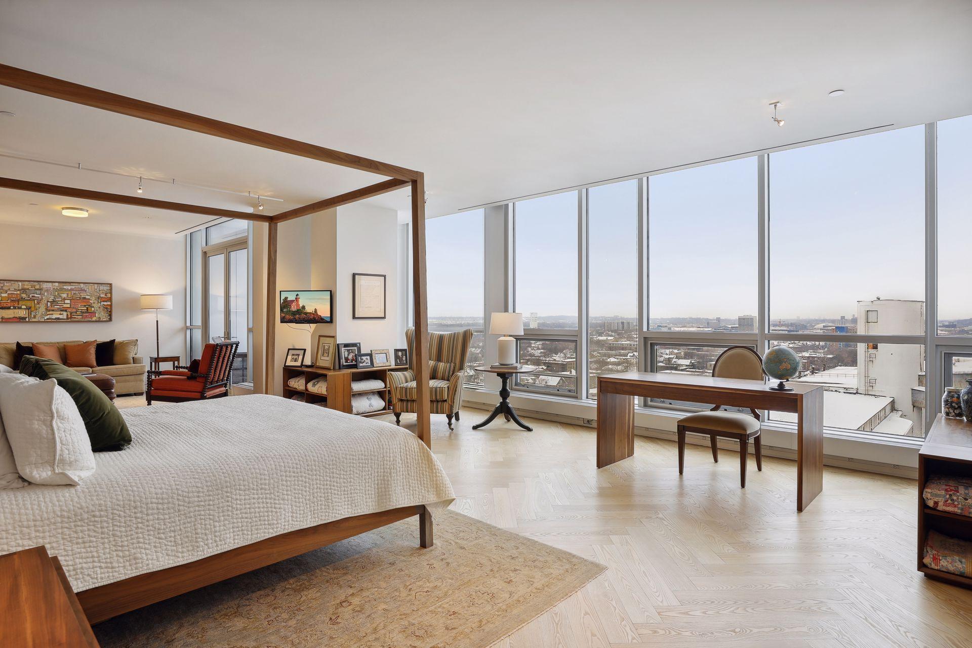 The upper level primary suite features black ash herringbone floors, floor to ceiling windows, sunrise views above the neighborhood buildings, a separate sitting area, private terrace, a walk-in closet, and a luxurious spa-like bath.
