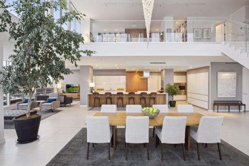 The dramatic two-story dining room features views of historic mill buildings and the city skyline, as well as a custom designed chandelier from the renowned Ferrari family.