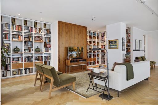 The library and den feature custom built in shelving and cabinets for book and art displays as well as a lovely walnut paneled accent wall.