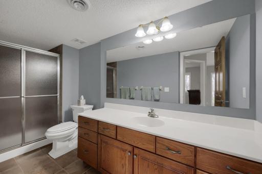 Lower level 3/4 bathroom is finished with ceramic tile and an oversized vanity for storage.