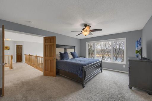 Upstairs you will discover your spacious primary suite. The large picture window has powered blinds! You don't have to get out of bed to open blinds to view the lake.