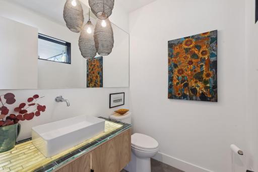 Accented with designer fixtures, the Powder Room features floating vanity with custom countertop.