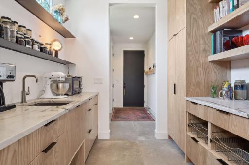 Nestled behind the kitchen is an impressive Butler's Pantry with a prep sink, and 8-foot pantry cabinets offering pull-out shelving and transom windows.