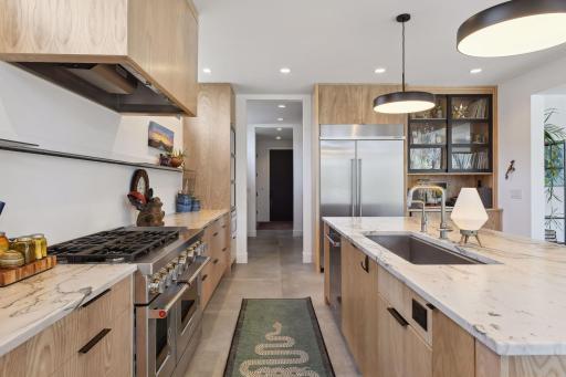 Sure to delight any chef, the kitchen is equipped with a professional KitchenAid appliance package that includes a 48-inch gas range with a 6 burner cooktop and side-by-side convection ovens.