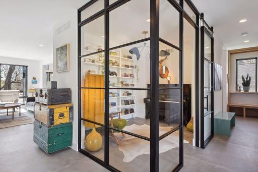 The perfect flex space, floor-to-ceiling metal and glass walls enclose the main level Home Office.