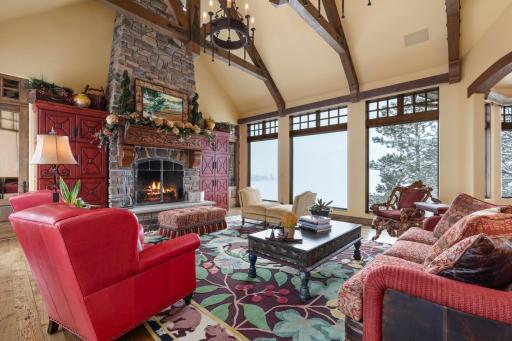 The great room features a timber beam cathedral ceiling and stone fireplace.