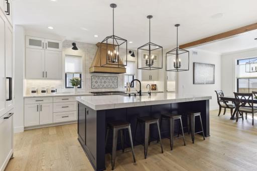 Chefs kitchen features oversized central island, Thermador appliances, quartz countertops.