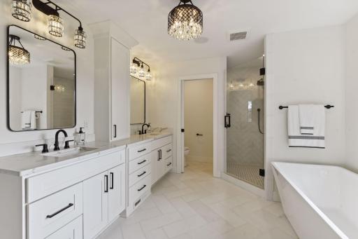 Spa like primary bathroom with custom heated marble floors, marble walk-in shower and freestanding tub.