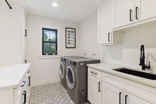 Convinient upper level laundry with plenty of storage cabinets.