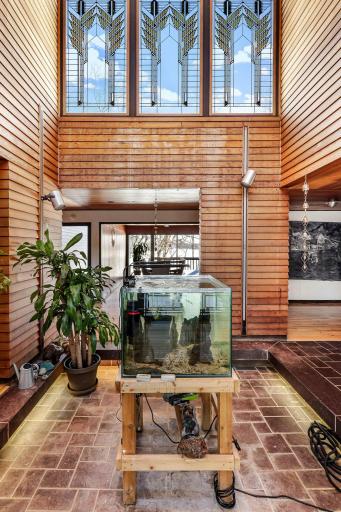 The stunning atrium offers an impressive space for plants (or a tree) with stained glass windows, a drain and a water spigot.