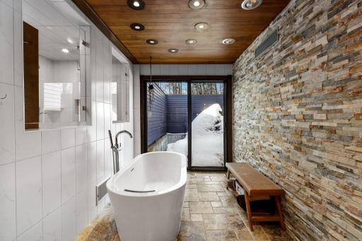 The primary bathroom features a spacious double vanity with built in storage, a separate soaking tub, a large walk-in shower and leads into the generous walk-in closet.