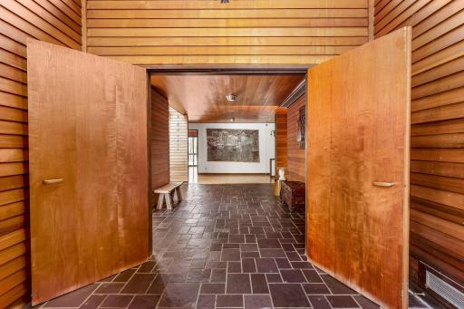 The grand foyer leads into the spacious home featuring white walls for fine art lighting, spacious hallways and doorways, exquisite stained glass windows and Frank Lloyd Wright inspired details throughout.