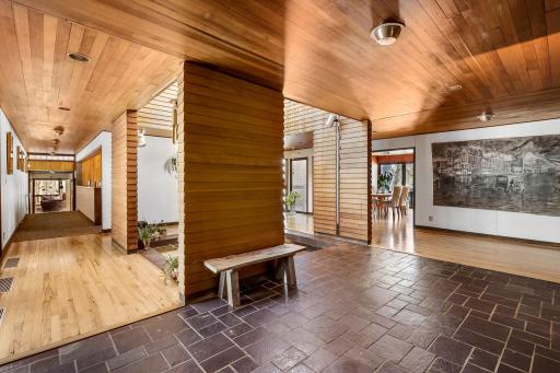 The grand foyer leads into the spacious home featuring white walls for fine art lighting, spacious hallways and doorways, exquisite stained glass windows and Frank Lloyd Wright inspired details throughout.