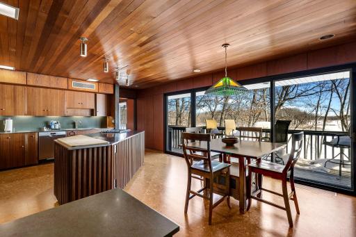 The eat-in kitchen features a walk-in pantry, indoor grill with ventilation, stone fireplace, double wall ovens, stainless counter tops and appliances, cork flooring, custom cabinetry and a 5 burner, gas cooktop.