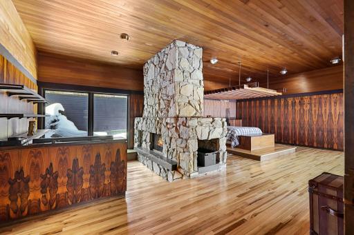 The primary suite features irreplaceable Brazilian Rosewood walls all cut from one tree, a built-in platform bed (adjustable to king or queen) with teak pergola, expansive views, and a sunk in sitting den with double-sided, see-through fireplace.
