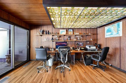 The office, nursery or extra bedroom off the primary has custom one of a kind-stained glass lighting and walks out to a screened in porch offering stunning views.