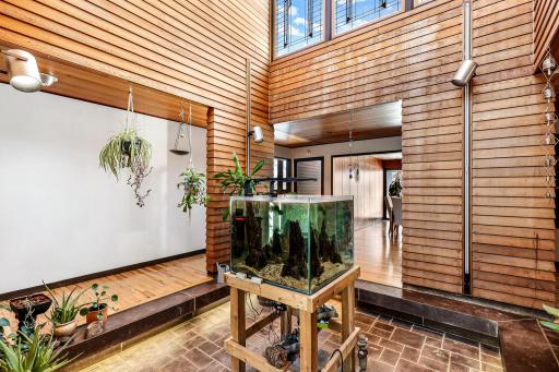 The stunning atrium offers an impressive space for plants (or a tree) with stained glass windows, a drain and a water spigot.