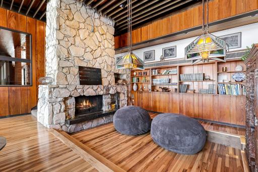 Enjoy stunning views from the living room featuring floor to ceiling windows, custom Frank Lloyd Wright replica lighting, custom Bollenbach stainless steel lighting, a sunk-in seating area with built-ins, 14-foot-tall ceilings and Teak walls.