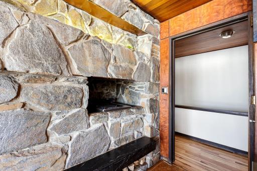 The eat-in kitchen features a walk-in pantry, indoor grill with ventilation, stone fireplace, double wall ovens, stainless counter tops and appliances, cork flooring, custom cabinetry and a 5 burner, gas cooktop.