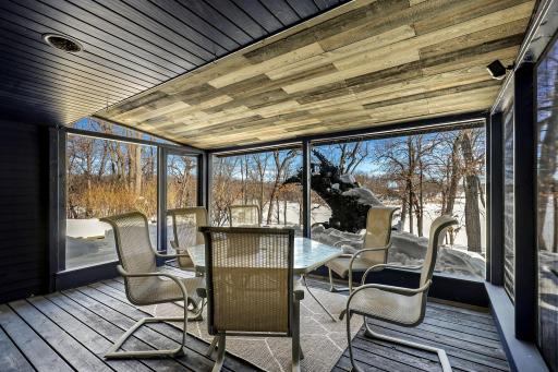 The office, nursery or extra bedroom off the primary has custom one of a kind-stained glass lighting and walks out to a screened in porch offering stunning views.