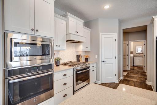 Additional upgrades include a gas range/oven + a separate wall convection oven below the microwave. Also, a sneak peek at the home's support areas (well-equipped laundry room & mudroom) just off the kitchen.