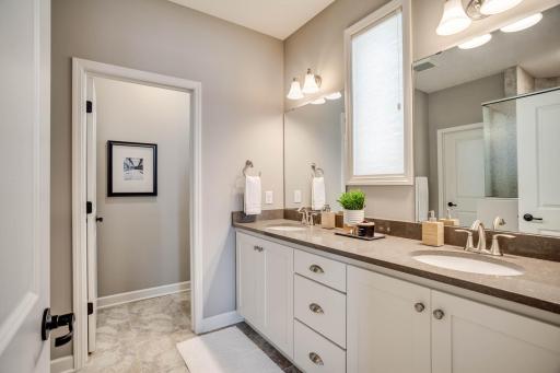 The owner's bath features quartz countertops, dual sinks, enameled cabinetry, shower & private water closet.