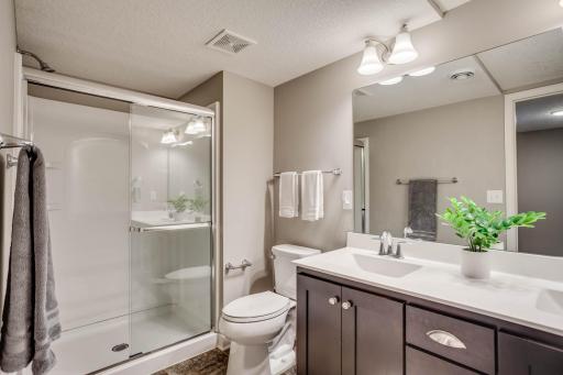 Great for sharing if needed, the 3/4 bathroom features dual sinks, LVT flooring and glass shower doors.