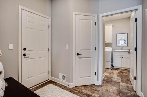 Easy maintenance & durable, luxury vinyl tiles flow throughout the home's wonderful support areas, including the mudroom with custom boot bench, laundry room with handy sink & storage, and large utility closet.