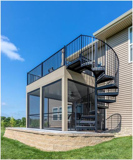 An excellent view of the premium outdoor additions, including the upper, maintenance free deck, the beautiful spiral staircase leading off the deck, and the spacious screened porch below! The home's landscaping includes professional retaining walls.