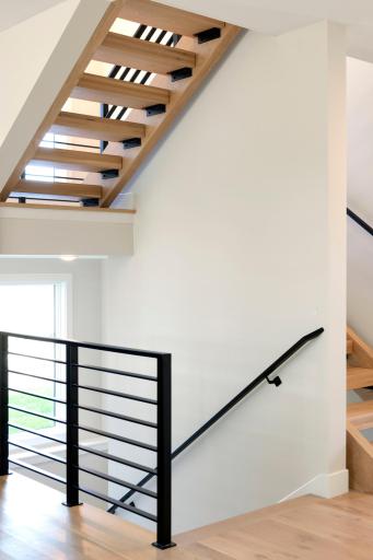 Custom Steel Railings & Open Wood Staircase Lead to the Upper Level