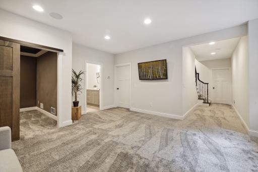 The lower level showcases the family room, theater room, three-quarters bathroom, and storage space.