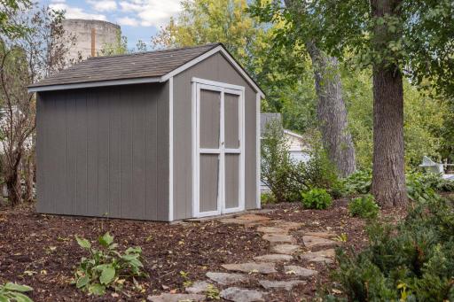 This charming shed is perfect for storing garden tools.