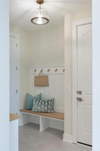 Custom bench with hooks right when you enter the home from the 3-stall garage