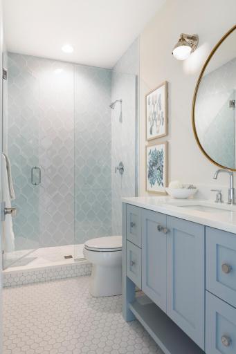 Fully tiled 3/4 bath with a pop of color pulls the cottage exterior inside