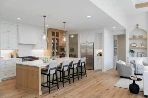 White oak island and curio cabinet blend nicely with the warm white and prefinished wood floors