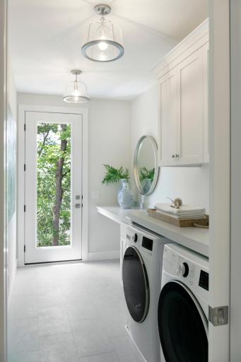 Laundry room features cabinetry and a folding counter along with backyard access (to patio) - great for letting pets out!