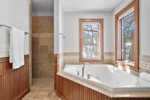 Large jetted soaking tub with expansive windows for relaxing sunlight or twilight views