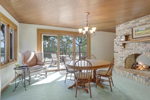 Semi formal dining room with see thru fireplace and sliding glass door to deck.
